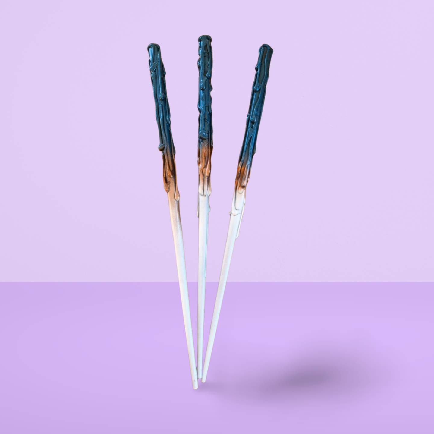 Three pairs of childrens wands with blue and white gradient handles on a light purple background