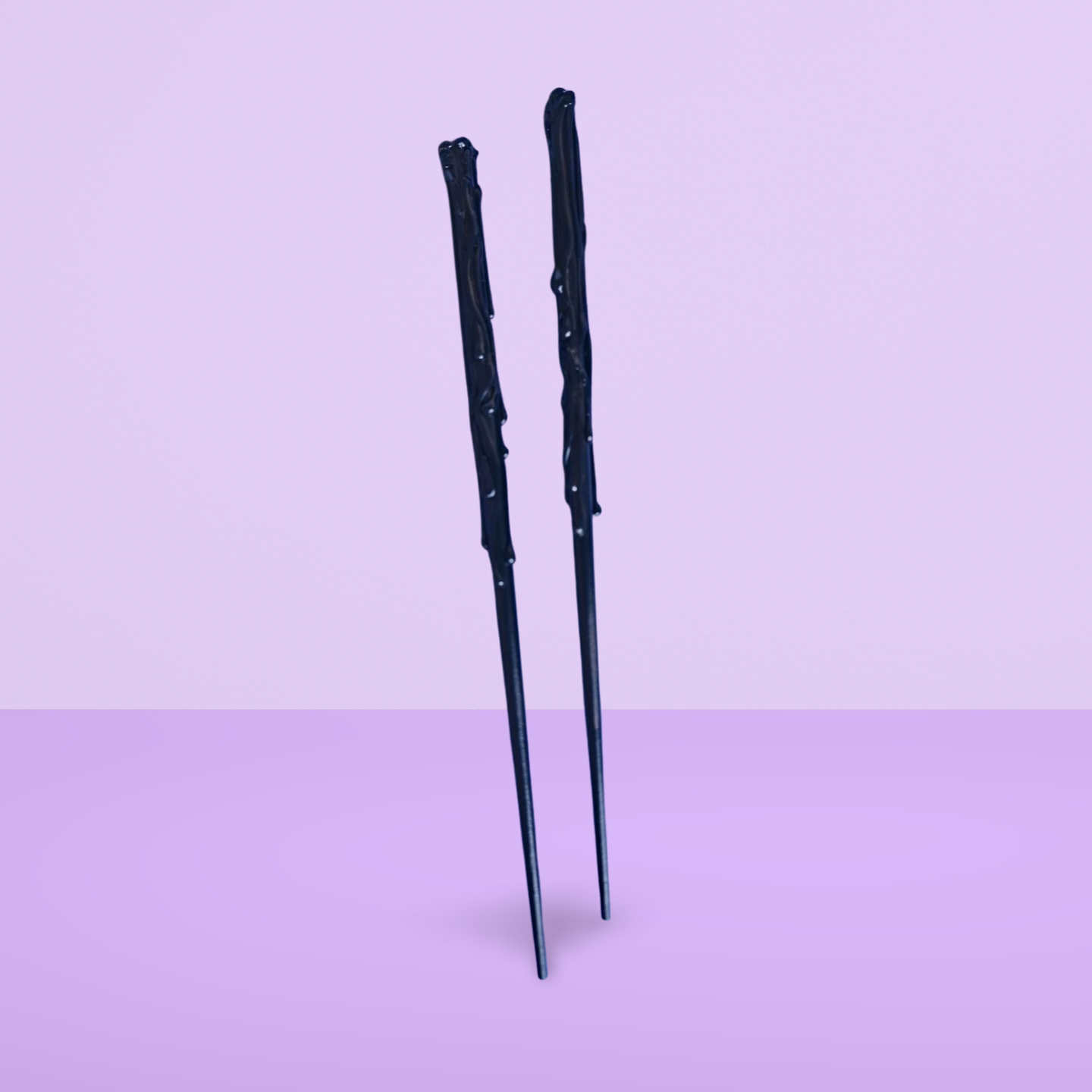 Two black wands on a light purple background