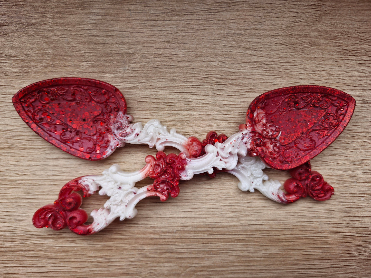 Decorative red and white spoon on a wooden surface