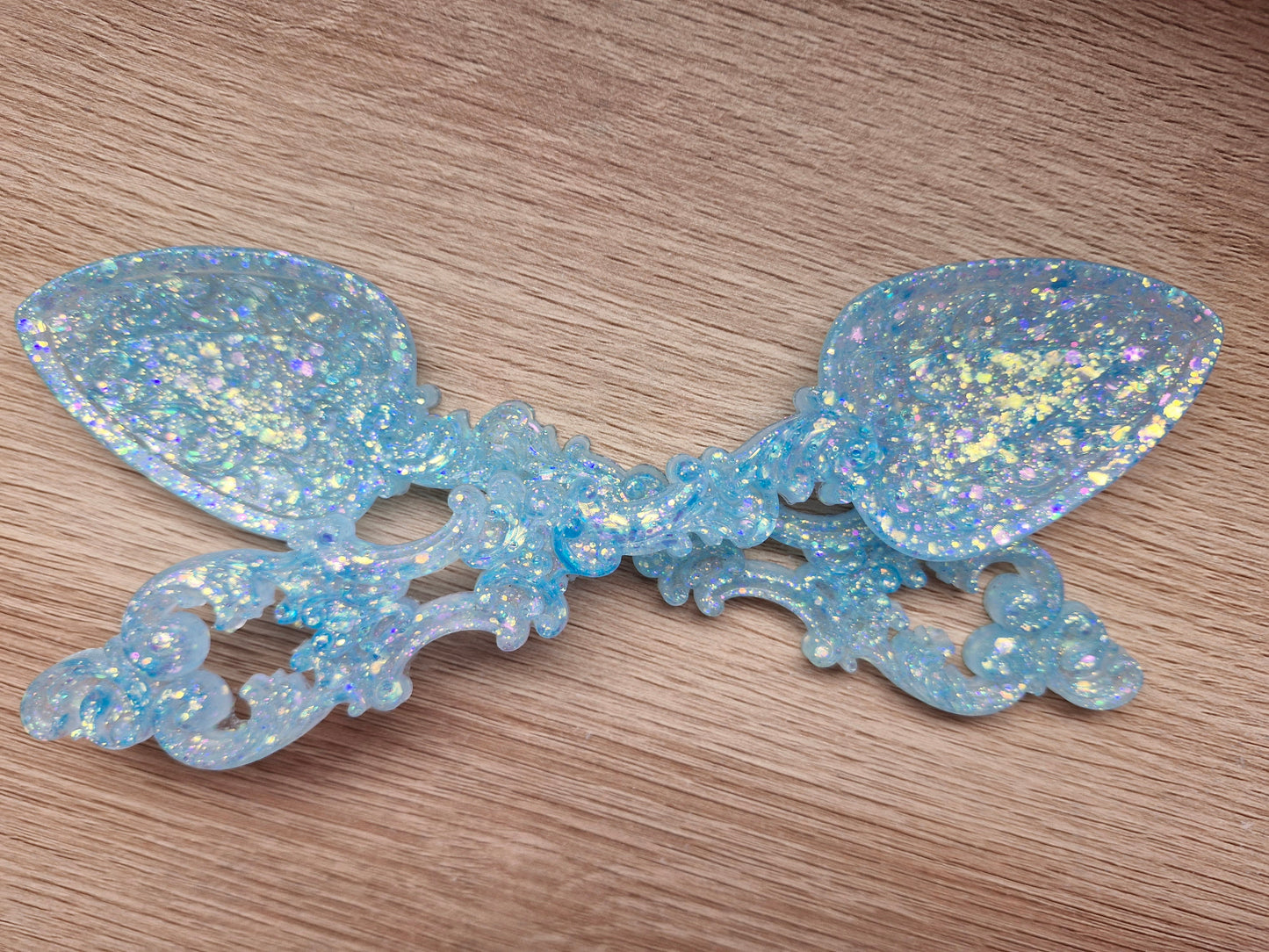 Decorative spoon with glittery blue finish on a wooden surface