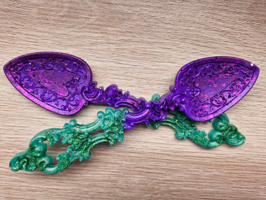 Decorative purple and green spoon on a wooden surface