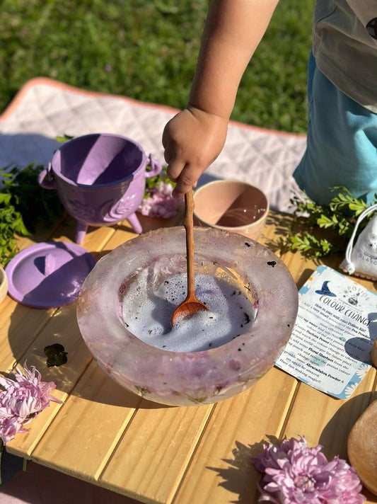 Child mixing potions in a frozen flower bowl