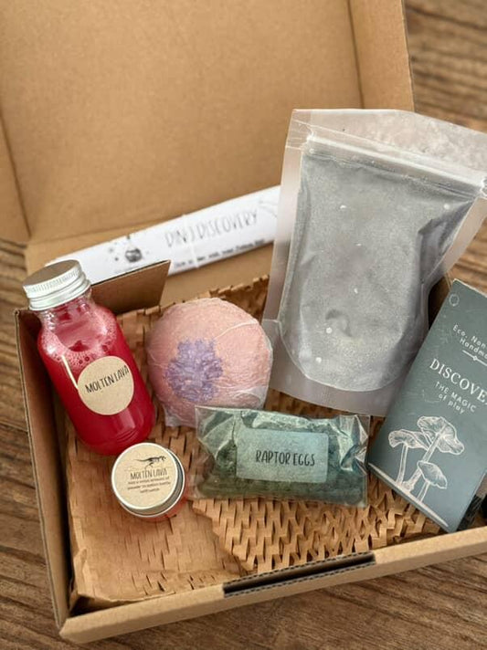 A box of dinosaur sensory play elements. Fizzy potion box.