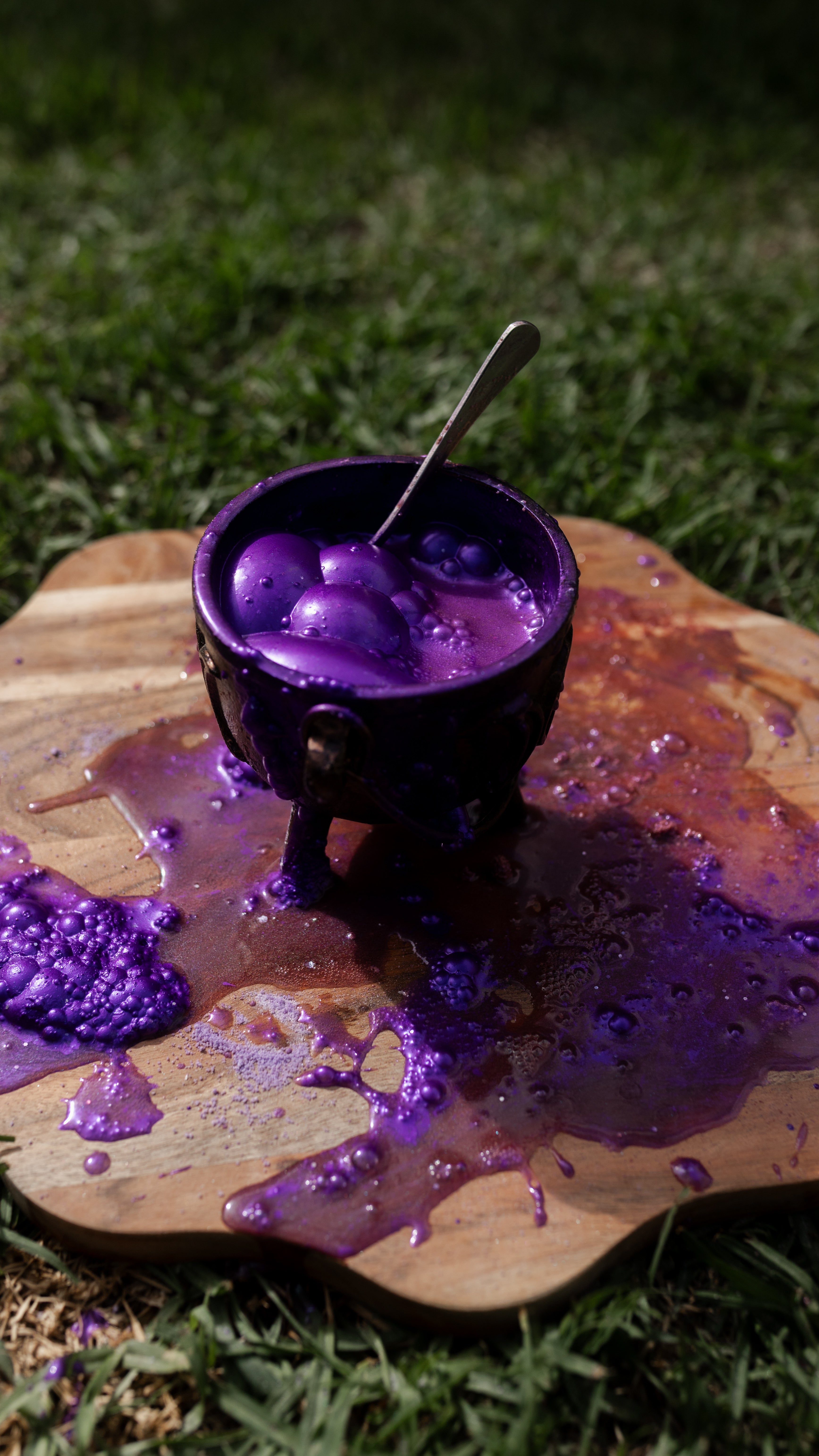 childs cauldron overflowing with purple potion bubbles
