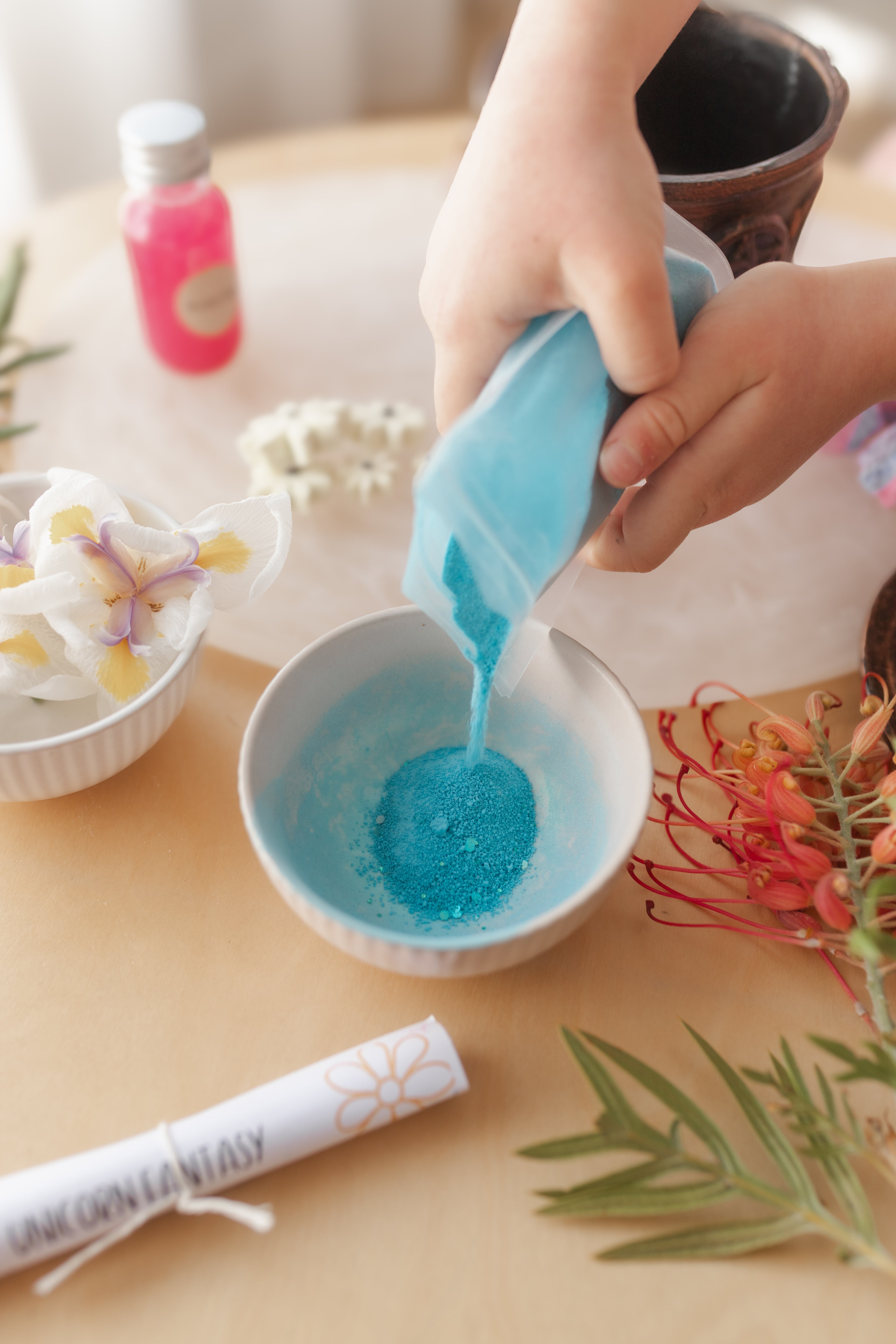 child pouring blue fizzy potion powder into a bowl